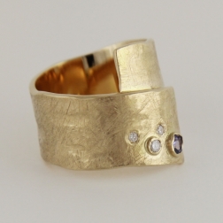 Złoty pierścionek-taśma z brylantami i tanzanitem.