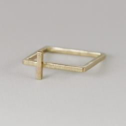 Gold cross on a square ring.
