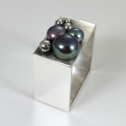 Szeroki kwadratowy pierścionek z perłami.